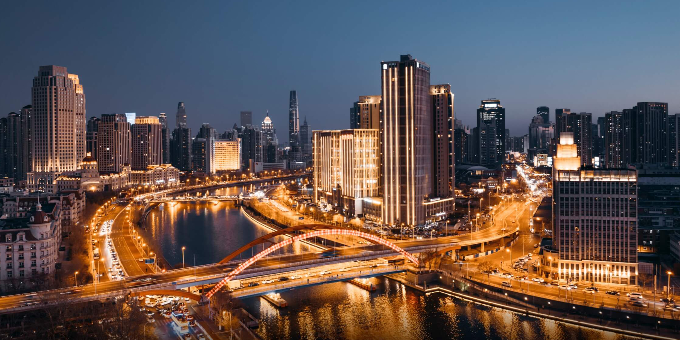 Aerial view of Tianjin, China, showing the illuminated city skyline at sunset, captured with the DJI Mavic 3 Pro.