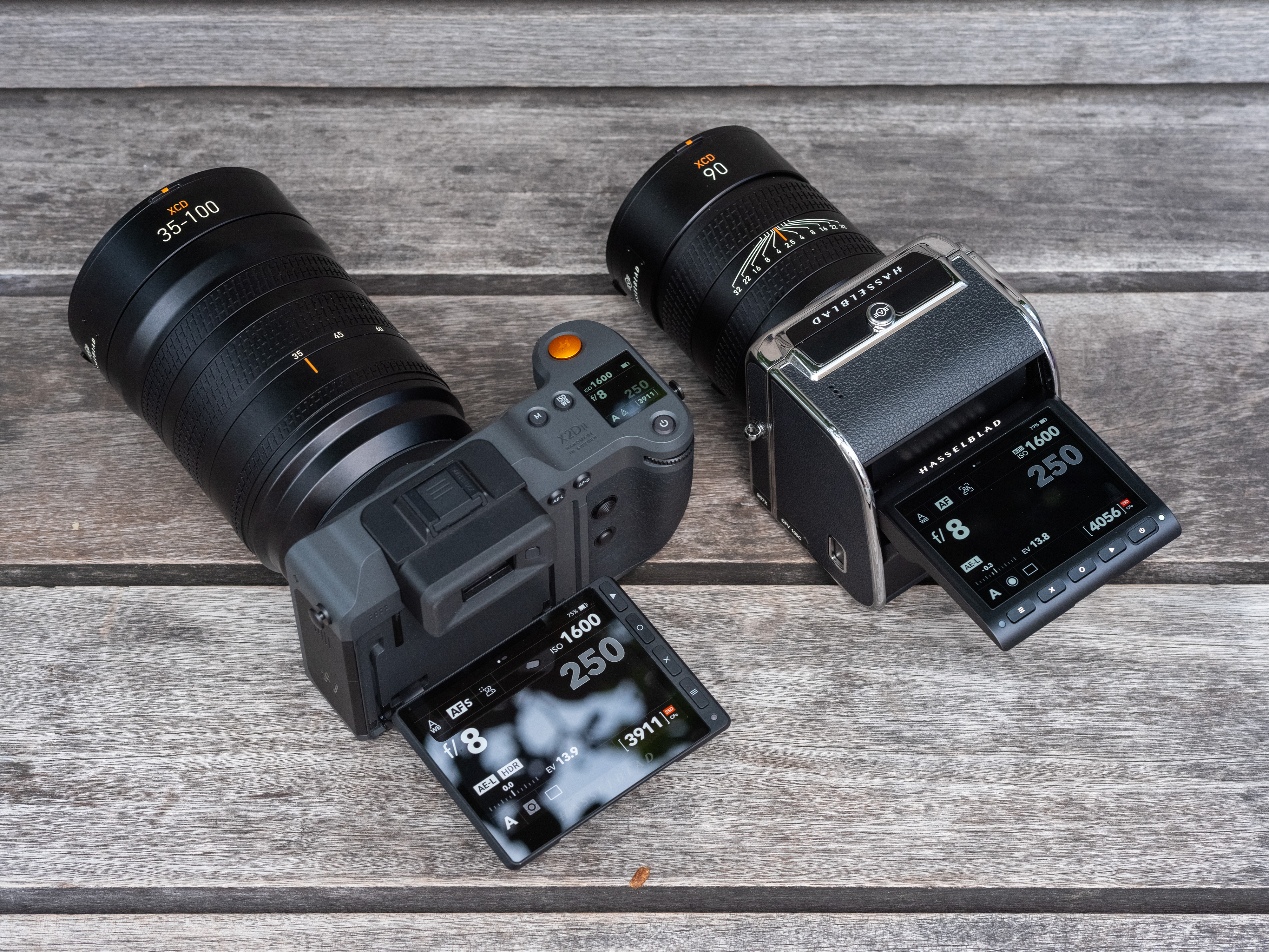Hasselblad X2D II 100C next to the 907X & CFV 100C, with rear LCDs tilted upward