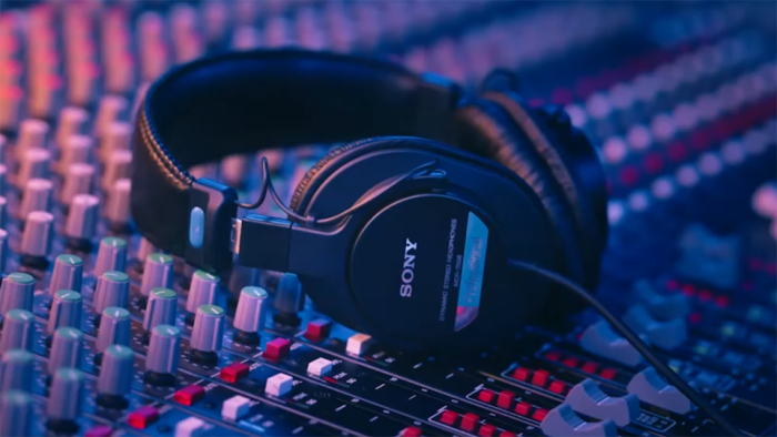 Headphones resting on a mixer in a studio