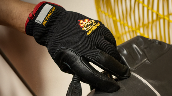 Person's hand wearing a black protective glove
