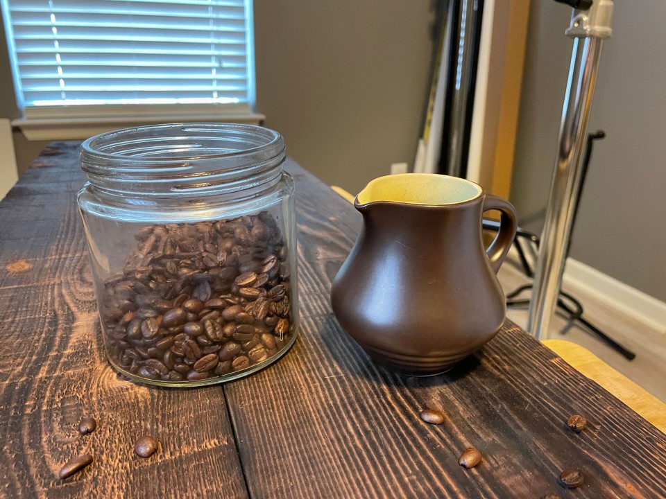 A jar of coffee beans and a pouring cup
