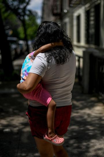 Mercedes poses for a portrait with her daughter down the street from her apartment building in the Washington Heights neighborhood of Manhattan, New York on June 19, 2020. Mercedes, who has no income since her husband lost his construction job due to the pandemic, is unable to receive unemployment benefits because of their immigration status. © Desiree Rios for The New York Times