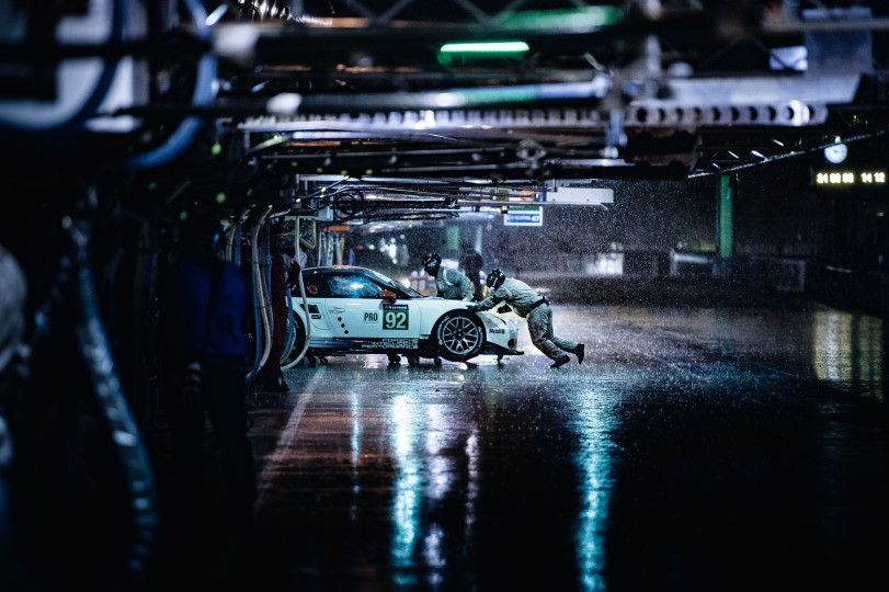 Pit crew pushes the 92 Porsche back into the garage after a surprise heavy rain storm during practice for the Le Mans 24-hour race. Nikon D4, ISO 800, 200 mm f/2.8 lens at 1/250.