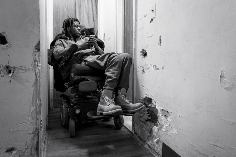 Malik maneuvres his wheelchair in the narrow hallway of his apartment.
