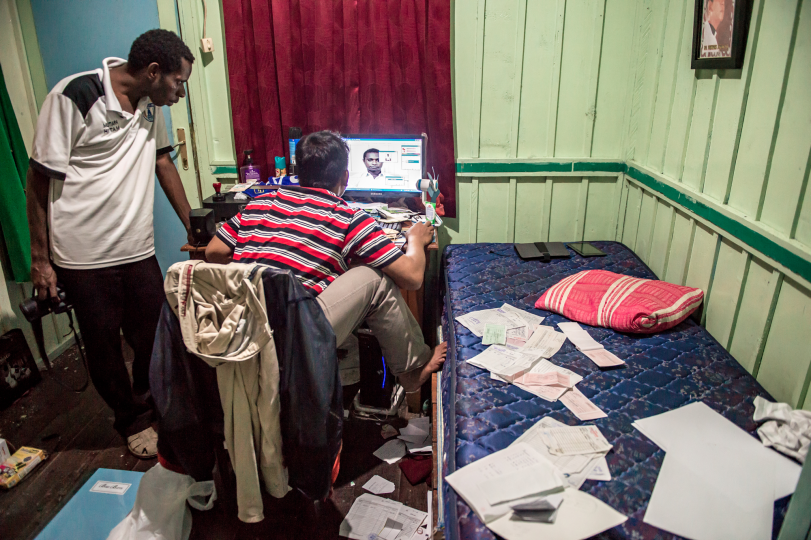 Catholic priests edit a passport photo for an Asmat student in the priest’s house, Agats, 7/10/14.