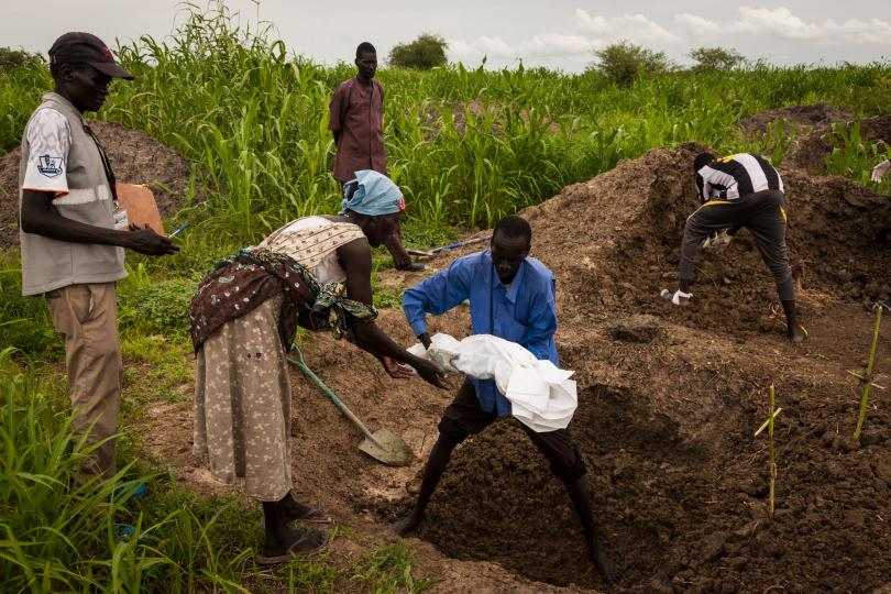 Martha helps to bury her six-month-old daughter, in a mass grave for children in the cemetery across the road from the UN base in Bentiu, South Sudan, June 30, 2014. Photograph © Adriane Ohanesian