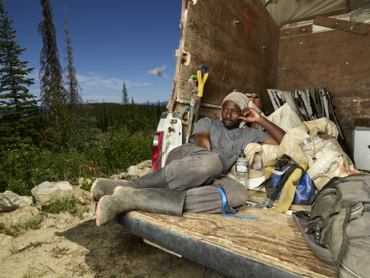 Tree Planter Bilal Basse takes a short break in the back of a truck between planting bag-ups, 2018