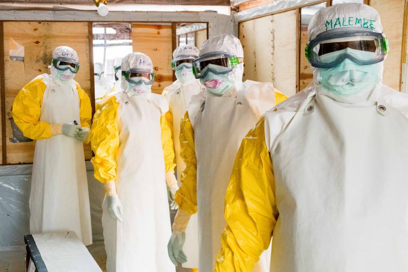 Healthcare workers pause for a photo as they finish dressing in their Personal Protective Equipment (PPE) at the beginning of the morning shift at the treatment center, in Butembo, the epicenter of the Ebola epidemic in North Kivu province in eastern Democratic Republic of Congo, March 5, 2019. © Adriane Ohanesian for The Wall Street Journal