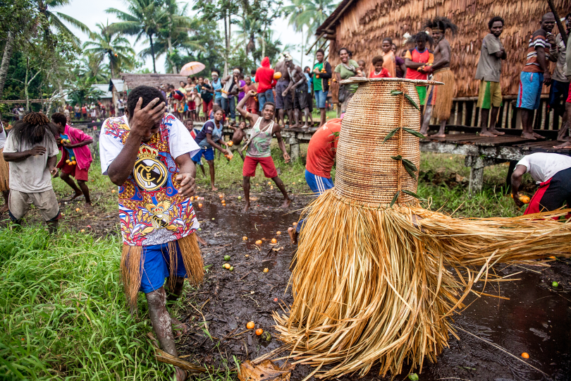 Villagers in Kapi toss “red fruit” (buah sanap) toward the manimar named “Hamtar” from the Amnes clan during the Jipae resurrection feast, 7/22/15. 