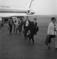 Ron Wood, Tony Newman, Jeff Beck, and Rod Stewart (hidden) deplaning with entourage to play at the Boston Tea Party as the Jeff Beck Group