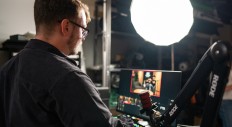 Peter at the mixing board with a RODE Professional Studio Arm and PodMic Dynamic Podcasting Mic.