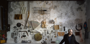 Jay Masiel poses in front of a wall of found objects inside his legendary bank building, NYC.