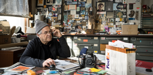 Jay Masiel on a mobile phone surrounded by memorabilia from his legendary bank building, NYC.