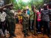 Marcellina, (center), who survived the militia attack, stands at attention over the grave of her colleague, Antopo Selemani, during the funeral of the Okapi Wildlife Reserve rangers outside of the town of Epulu, in the Democratic Republic of Congo, July 17, 2017. © Adriane Ohanesian