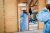 Ebola survivor and "Guardian of the Ill," Pamela Kiyangaliya, age 33, gets dressed in her Personal Protective Equipment (PPE) as she prepares to start her morning shift at the treatment center, in Butembo, the epicenter of the Ebola epidemic in North Kivu province in eastern Democratic Republic of Congo, March 5, 2019. © Adriane Ohanesian for The Wall Street Journal