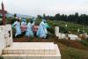Ebola responders with an armed police escort run with one of two coffins to be buried at the cemetery, on a hill in Butembo, in North Kivu province in eastern Democratic Republic of Congo. The responders have been a frequent target in attacks by community members and militias, March 6, 2019.  © Adriane Ohanesian for The Wall Street Journal