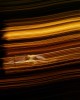 A paintbrush streak effect created by backlit trees standing between Thrasher and a car when using a long lens and a slow shutter speed during sunset at Le Mans 2022. Nikon D5, ISO 50, 500 mm f/8 lens at 1/6 second.