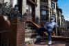 Residents wear face masks while sitting on the stoop of their building in the Morrisania neighborhood of The Bronx, New York on April 14, 2020.  © Desiree Rios for The New York Times