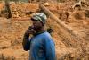 Diego Salimoali, age 37, stands with a pet brown lemur as he watches men work in the largest sapphire mining site in Bemainty, July 29, 2018. © Adriane Ohanesian